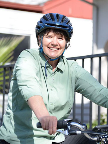 An image of Sister Libby smiling on a bike