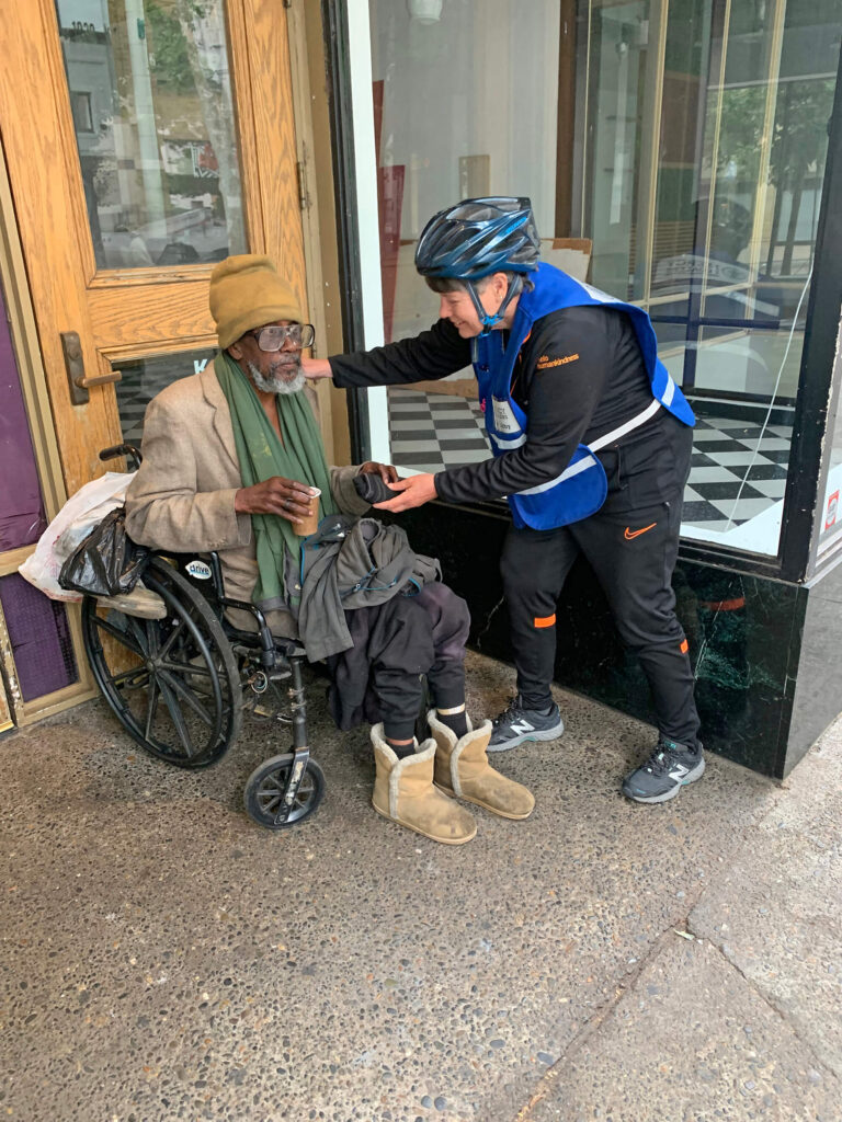 Sister Libby helping homeless man in wheelchair